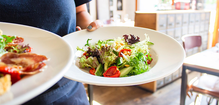 Person holding plates with food