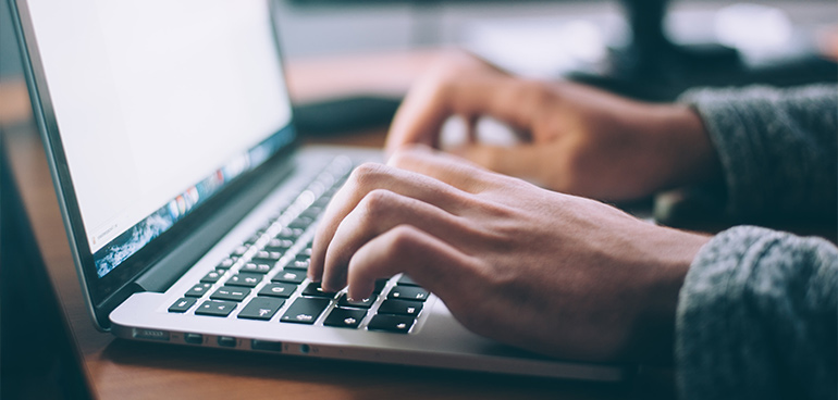 hands typing on laptop to illustrate food safety training