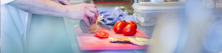 person cutting tomato, illustrating food preparation
