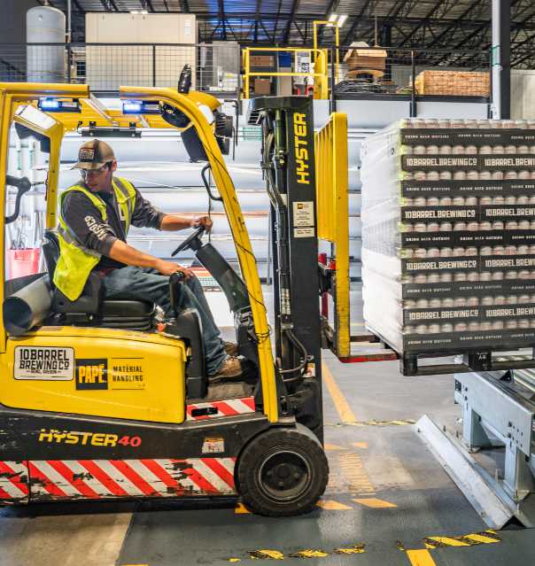 person driving forklift in warehouse to illustrate brcgs standards