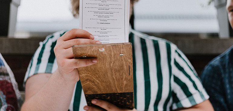 person holding menu to illustrate calorie labelling regulations for food