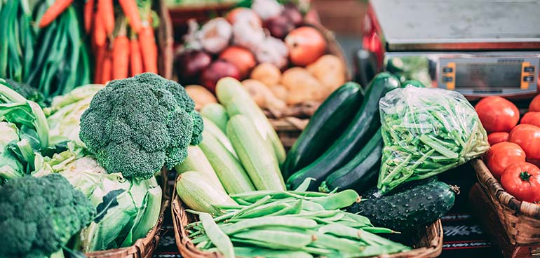 vegetable display with broccoli, beans, cucumber and other colourful vegetables