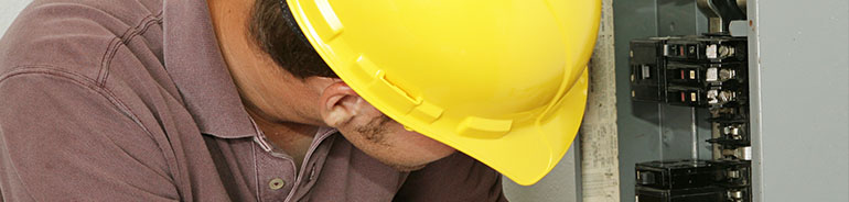 person wearing a protective yellow helmet undertaking electrical work