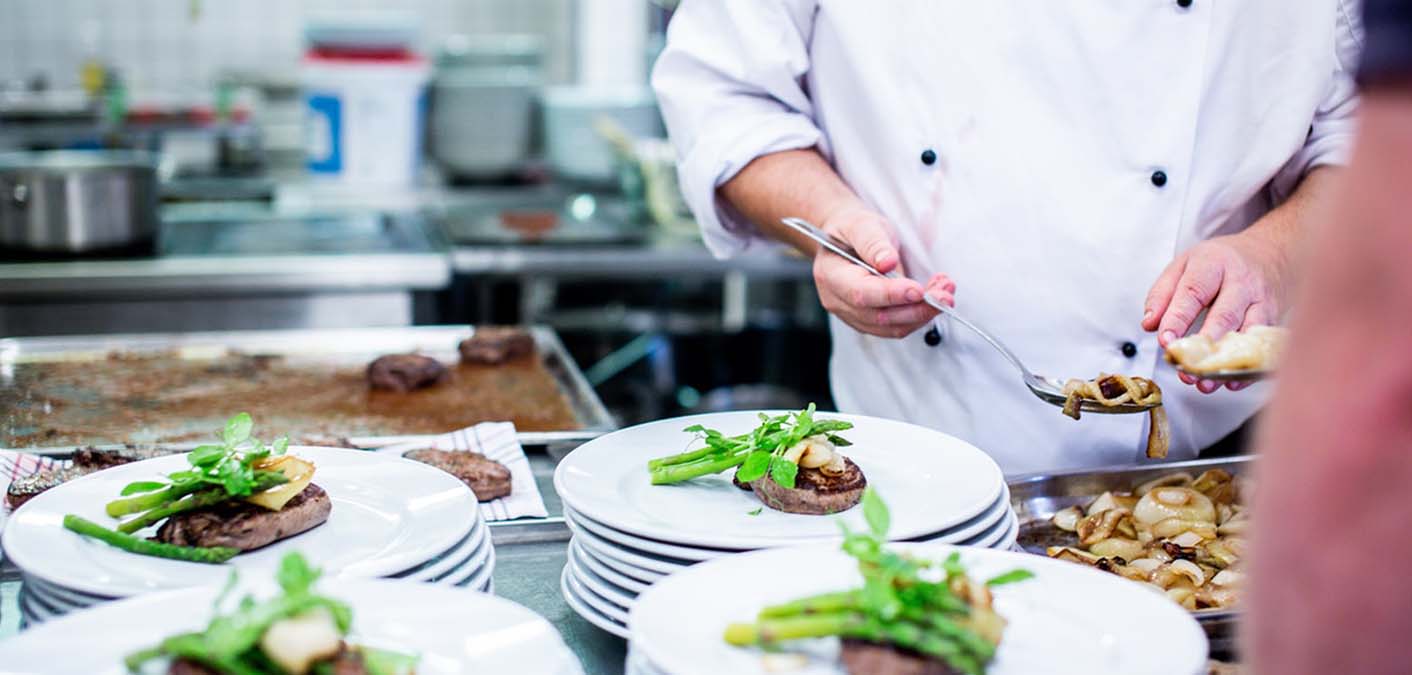 chef in kitchen preparing dish to illustrate four cs of food safety